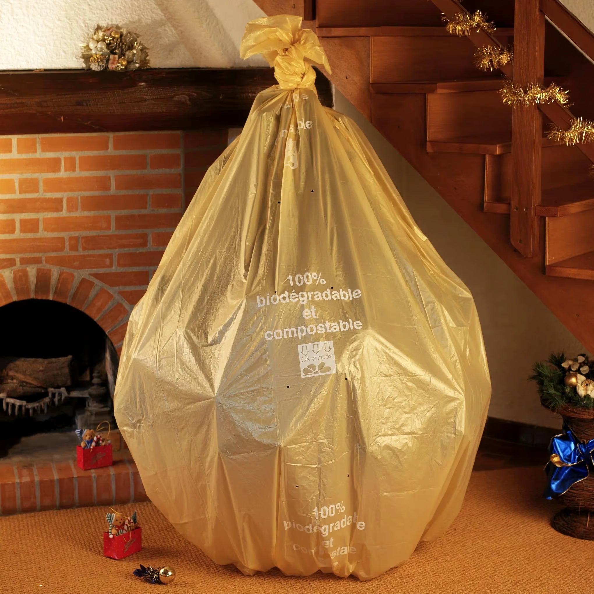 Sac à sapin doré biodégradable au pied d’un sapin de Noël naturel 